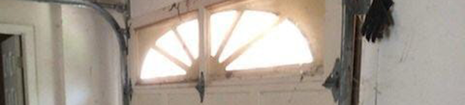 Cracked and dented garage door panel before replacement on Dallas TX home garage